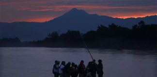 Migrants cross the Suchiate river on a raft.