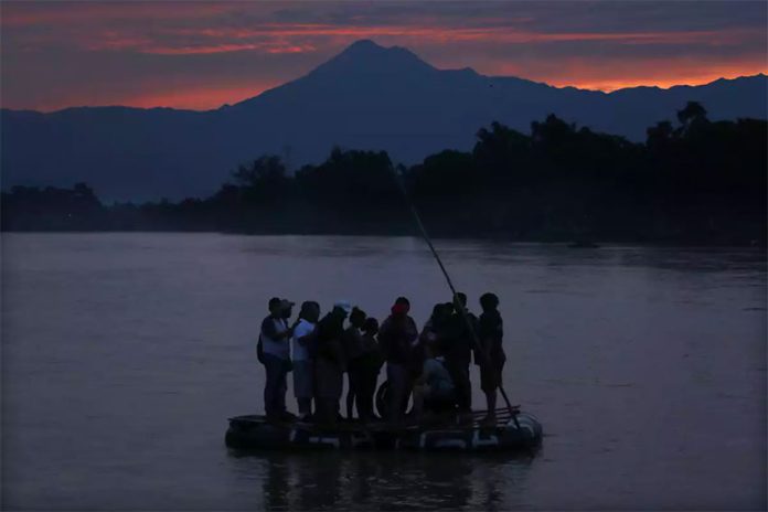 Migrants cross the Suchiate river on a raft.