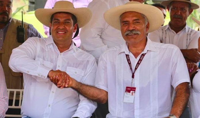 Undersecretary Peralta and self-defense force founder Mireles shake hands in La Huacana.