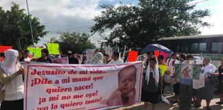 Abortion law protesters in Oaxaca. The sign reads: 'Jesus, tell my mother that I wish to be born!'