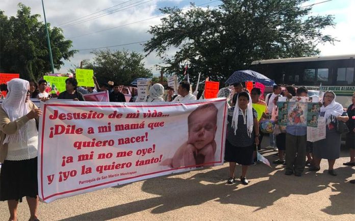 Abortion law protesters in Oaxaca. The sign reads: 'Jesus, tell my mother that I wish to be born!'