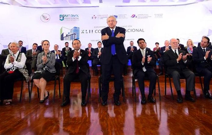 AMLO offers one of his trademark hugs at yesterday's conference.