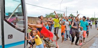 African migrants attempt to stop UN officials from leaving new registration center.