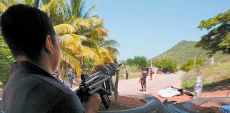 A state police officer mans a checkpoint in Tepacaltepec, Michoacán.