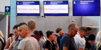 Travelers at the closed Thomas Cook check-in desk in Cancún.