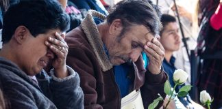 Relatives grieve at the memorial for slain Michoacán police officers.