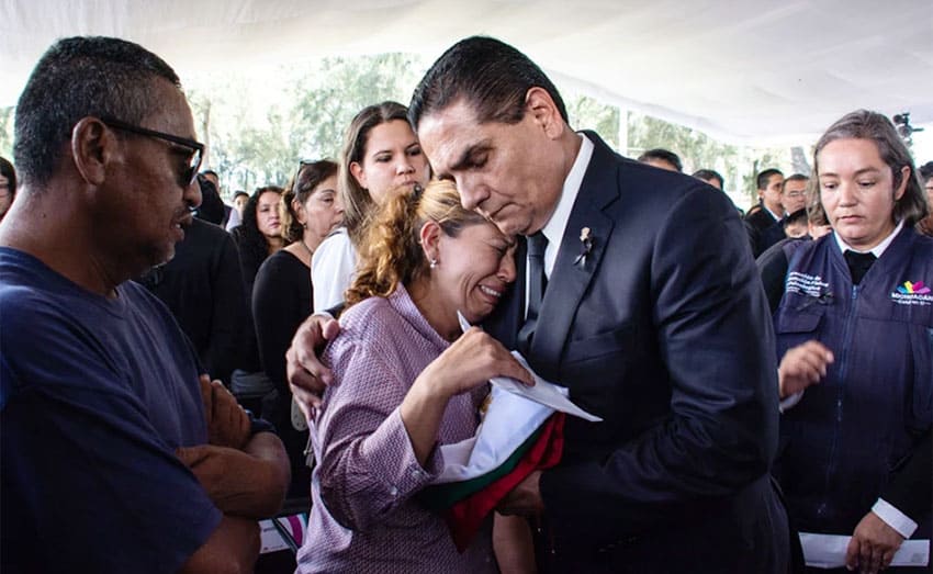 The governor comforts a survivor of a victim in Monday's attack.