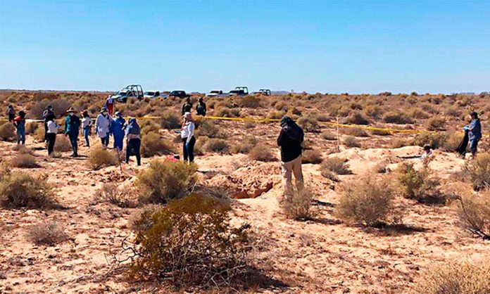 Searchers at the site where the bodies were found.