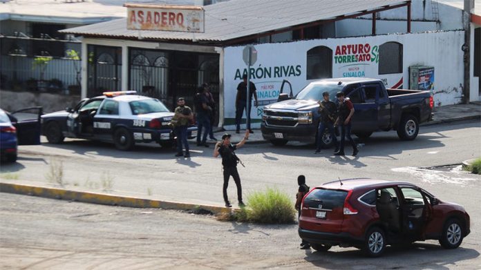 Armed civilians control a street corner in Culiacán.