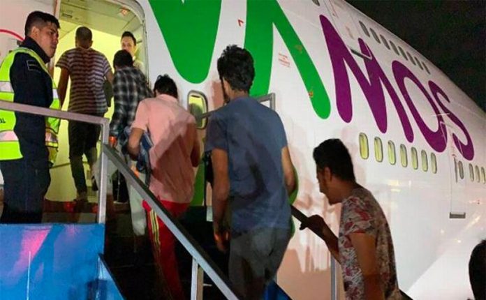 Undocumented migrants board their plane for India.