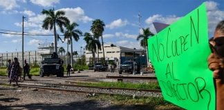 'Don't blame the warden,' reads the sign held by a protester
