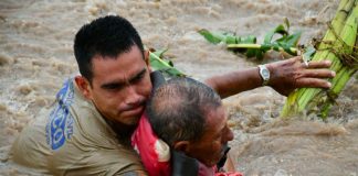 A rescue worker pulls a man out of floodwaters in Jalisco.