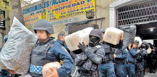 Police remove drugs from a Mexico City property after a raid on the Unión de Tepito.
