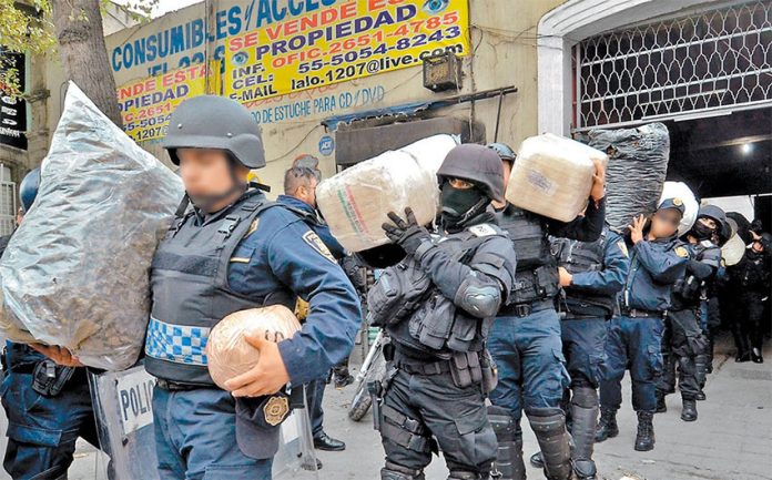 Police remove drugs from a Mexico City property after a raid on the Unión de Tepito.