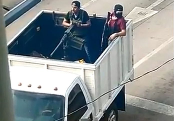 Cartel gunmen with a machine gun mounted in the back of a truck