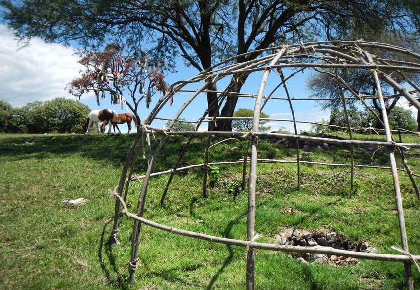 When covered with blankets, this wooden framework becomes a sweat lodge.