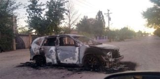 A burned-out vehicle blocks a road in Agua Prieta Monday morning.