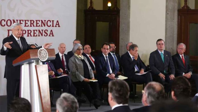 Cabinet secretaries listen as President López Obrador presents infrastructure plan.