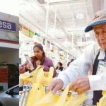 A senior bags groceries at a Sumesa store.
