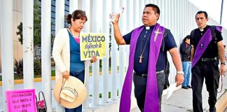 A priest blesses the precincts of the legislature during an exorcism.