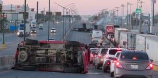 A burned vehicle blocks a highway in Nuevo Laredo Friday.