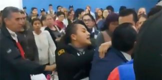 A security guard, center, breaks up a fight in Mexico City airport.