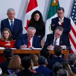 López Obrador and other officials witness the signing of the accord.