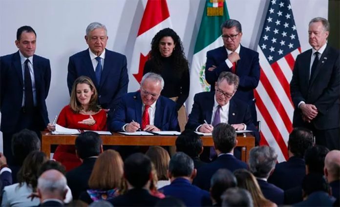 López Obrador and other officials witness the signing of the accord.
