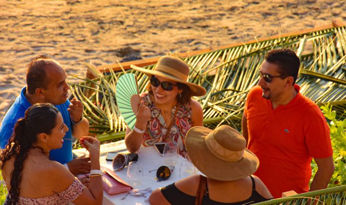 Guests enjoy wine festival on the beach at Zihuatanejo.