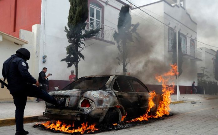A vehicle burns during Thursday's protest in Amozoc.