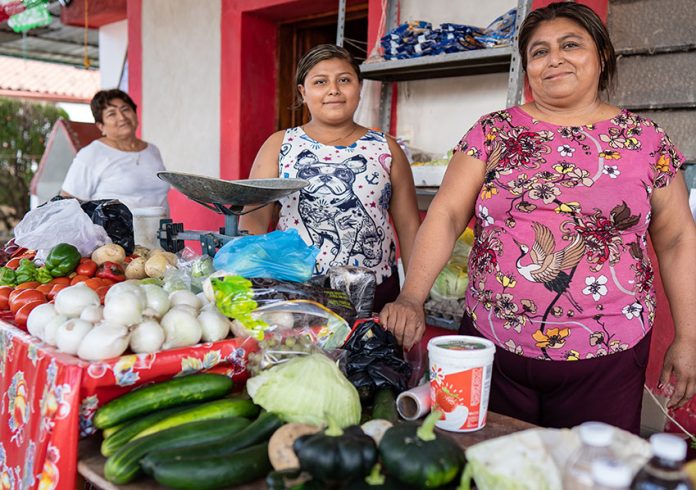 Flora, right, at her fruit and vegetable stand in Tenabo, Campeche.