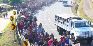 Migrants march north from the border Thursday morning.