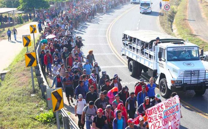Migrants march north from the border Thursday morning.