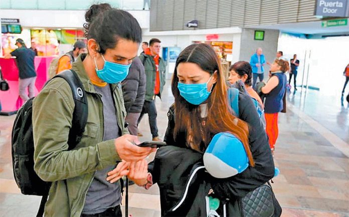 Travelers don masks for protection against coronavirus.