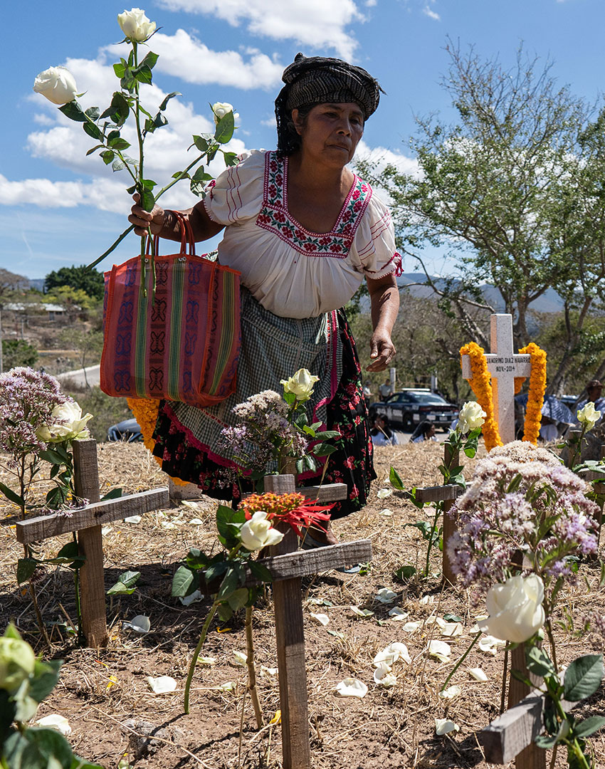 Before Sunday's march, a woman places flowers on the crosses that represent those who have disappeared.