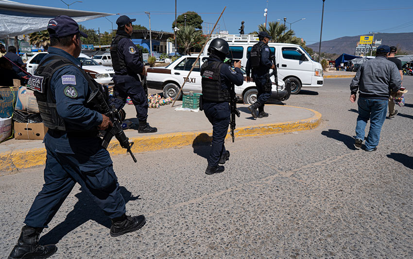 Federal Police officers guard the LeBaron family as they meet people in Chilapa, Guerrero.