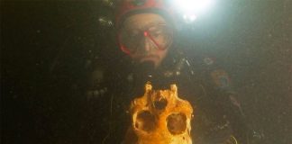 A diver with the skull of Chan Hol 3.