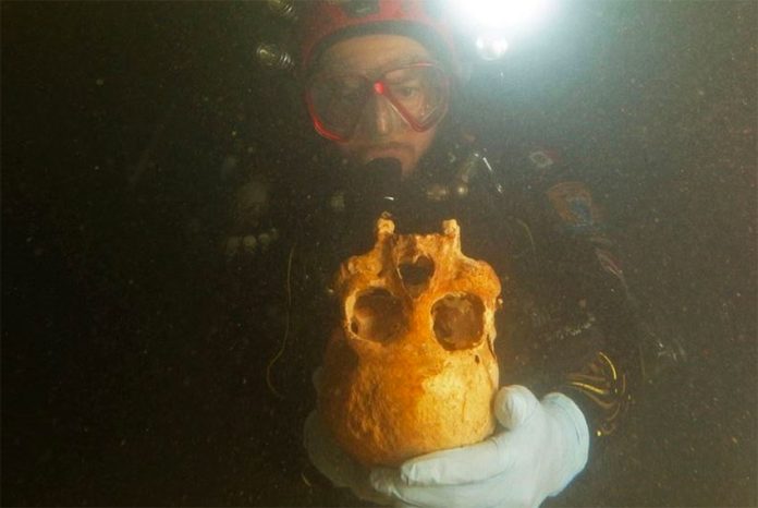 A diver with the skull of Chan Hol 3.
