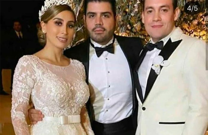The groom, center, with El Chapo's daughter and a guest at the wedding in Culiacán.