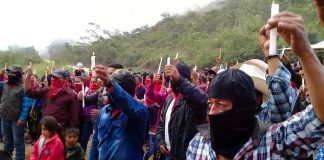 Zapatistas raise candles in protest against megaprojects.