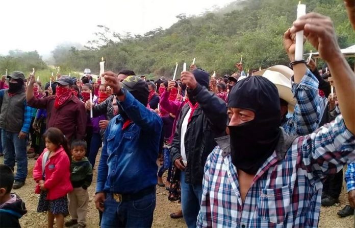 Zapatistas raise candles in protest against megaprojects.