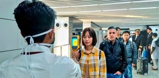 A health worker takes the temperature of arriving passengers in Mexico City.