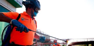 A worker at a transit station in Nuevo León sprays disinfectant.