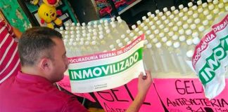 A Profeco agent seizes a product being sold as hand sanitizer.