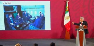 The president displays a photo of Peña Nieto and his cabinet aboard the presidential plane.