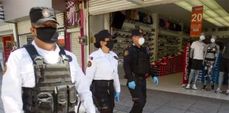 Masked security personnel on patrol in a shopping center.