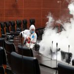 A worker sprays disinfectant in the Senate.