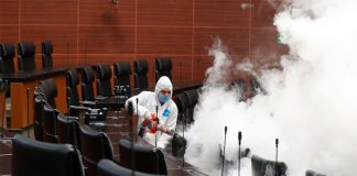A worker sprays disinfectant in the Senate.