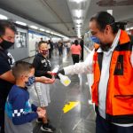 A Mexico City Metro worker dispenses hand sanitizer for passengers.