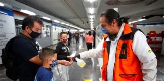 A Mexico City Metro worker dispenses hand sanitizer for passengers.